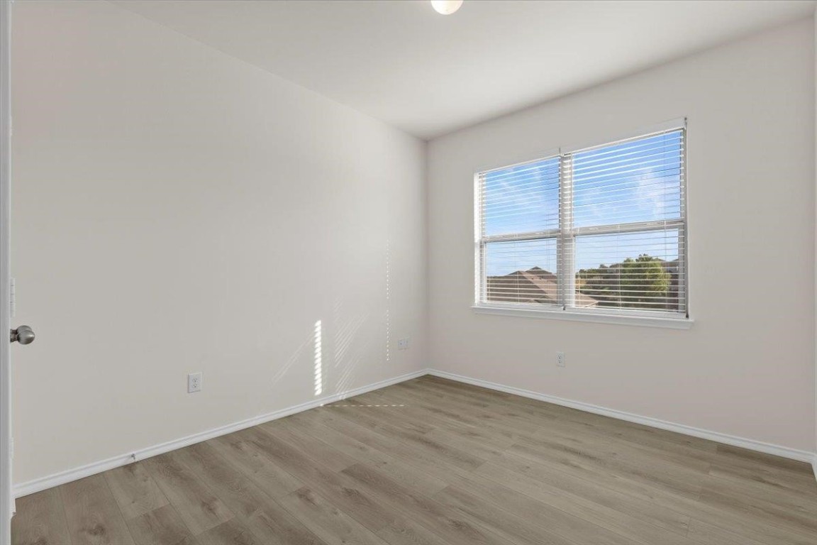 128 Dodge Road Georgetown, TX 78626 - Photo 11 of 18 an empty room with wooden floor and windows