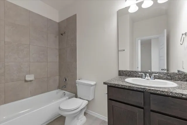 a bathroom with a granite countertop sink a toilet a mirror a bathtub and shower