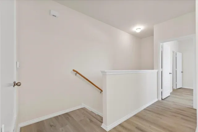 a view of a hallway with wooden floor and entryway