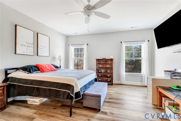 a bedroom with a bed a flat screen tv and dresser