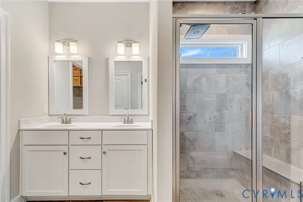 a bathroom with a shower sink and mirror