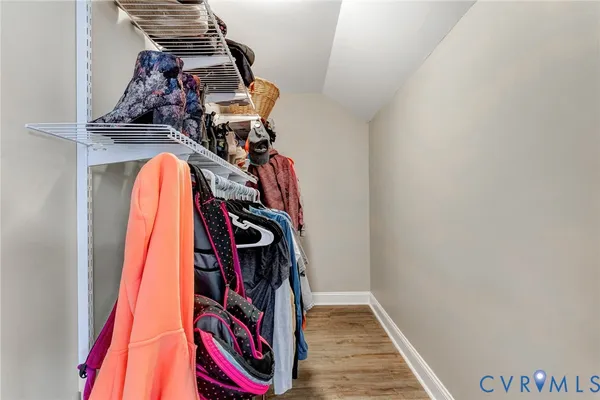 a view of walk in closet with clothes and shoes
