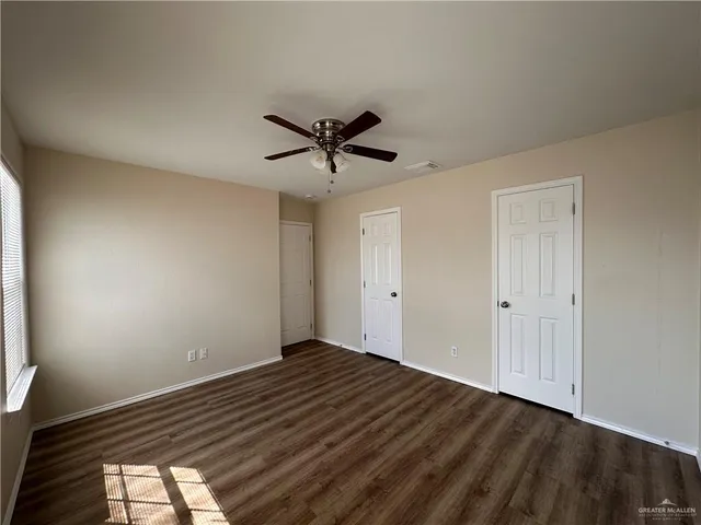 a view of room with a ceiling fan and wooden floor