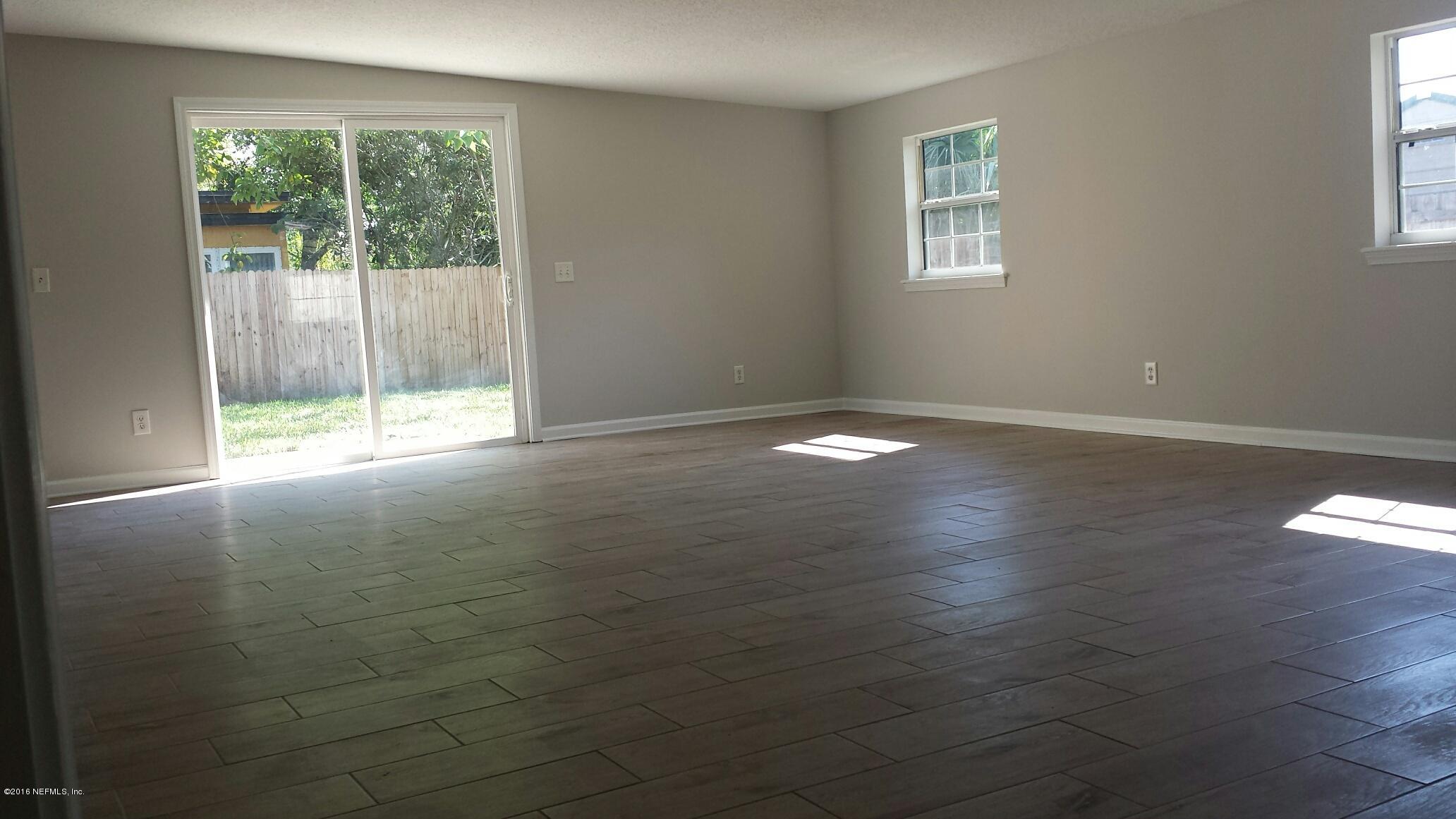 464 Sargo Road Atlantic Beach, FL 32233 - Photo 4 of 15 a view of an empty room with wooden floor and a window