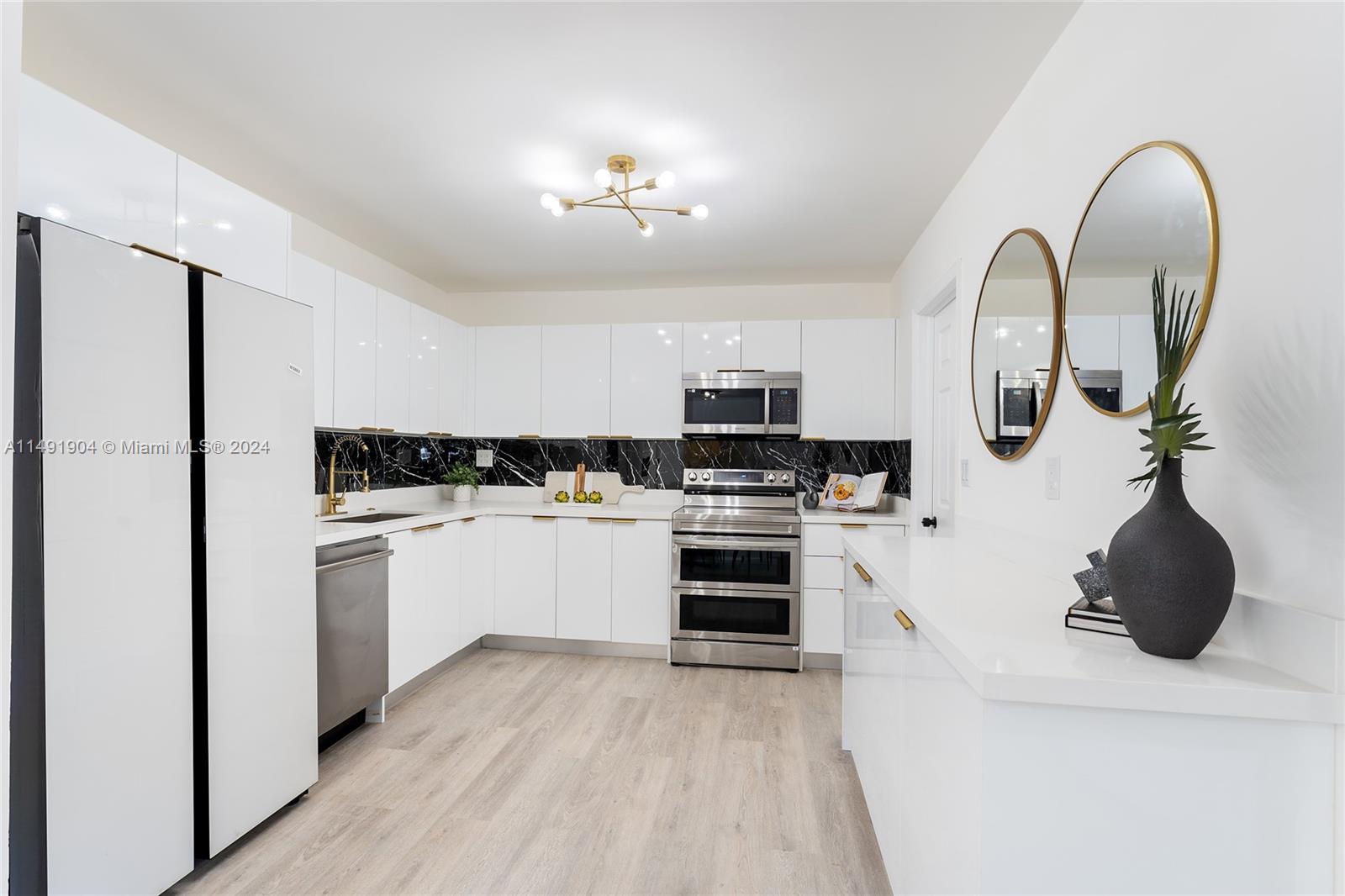 3254 Lincoln Street Hollywood, FL 33021 - Photo 12 of 27 a kitchen with stainless steel appliances a refrigerator sink and stove