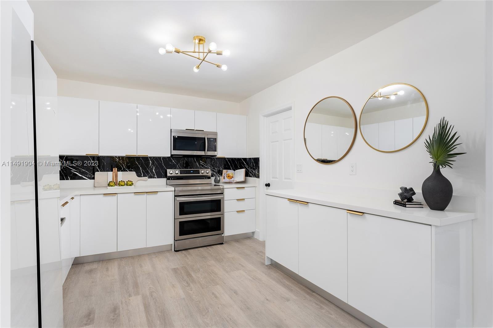 3254 Lincoln Street Hollywood, FL 33021 - Photo 13 of 27 a kitchen with white cabinets and appliances