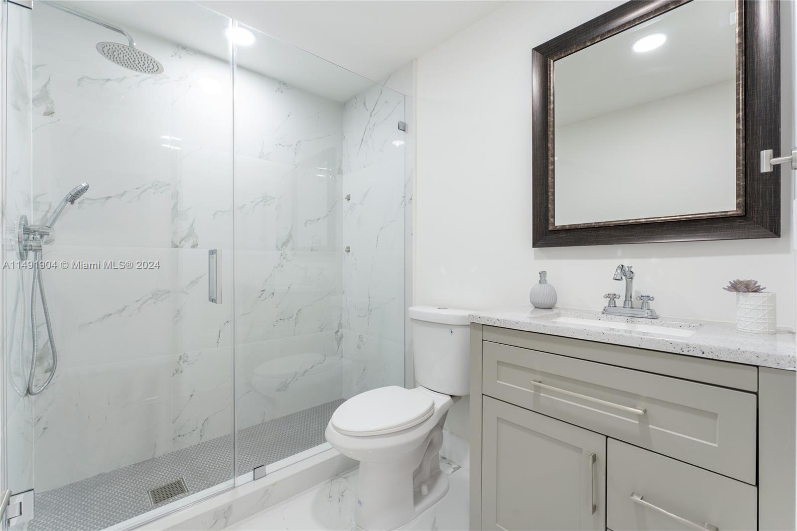 3254 Lincoln Street Hollywood, FL 33021 - Photo 20 of 27 a bathroom with a granite countertop sink a toilet and a mirror
