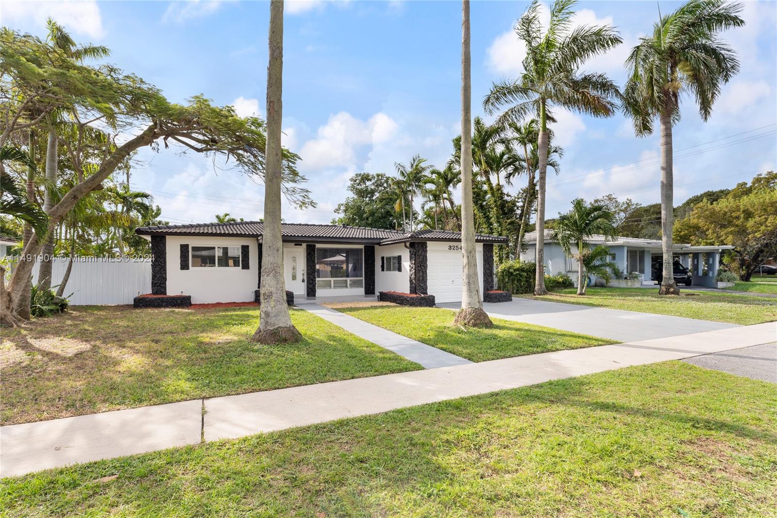3254 Lincoln Street Hollywood, FL 33021 - Photo 2 of 27 a view of a house with a yard and palm trees