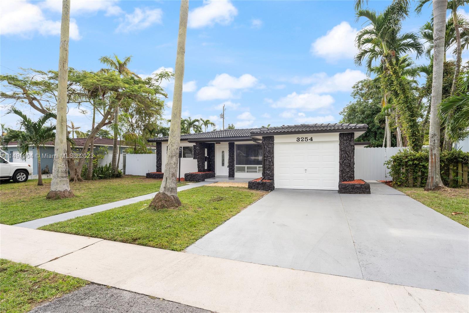 3254 Lincoln Street Hollywood, FL 33021 - Photo 3 of 27 a view of a house with a yard and a garage