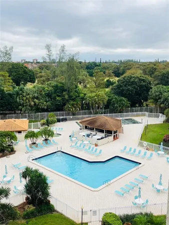 a view of a swimming pool with a patio and a yard