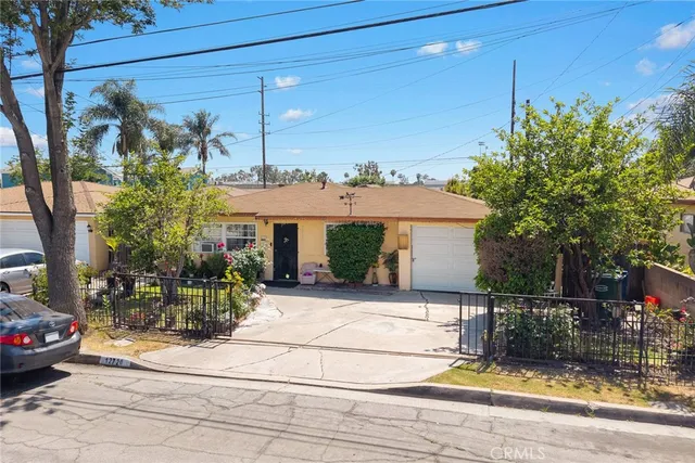 a view of a house with potted plants and large tree
