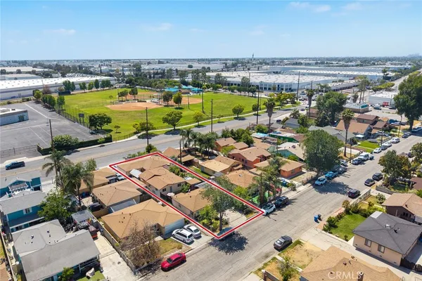 an aerial view of residential houses with outdoor space and trees