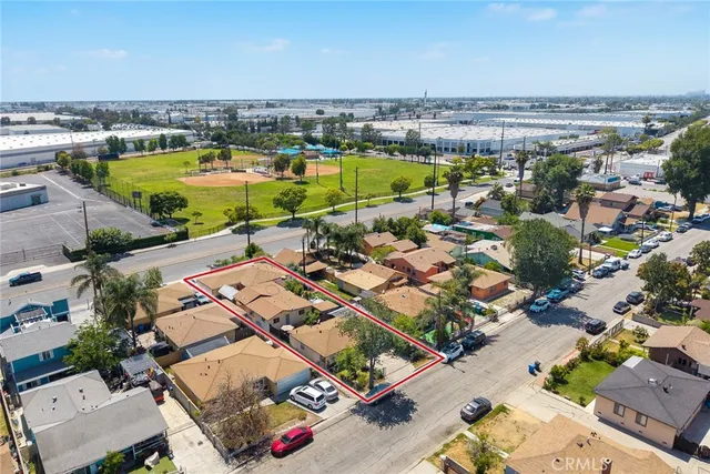 an aerial view of residential houses with outdoor space and trees