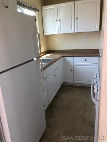 a utility room with cabinets washer and dryer
