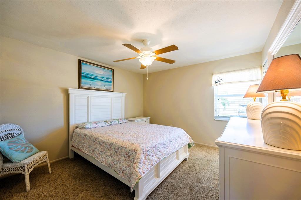 6777 Winkler Road, Unit 150 Fort Myers, FL 33919 - Photo 20 of 48 a bedroom with a bed and a chandelier