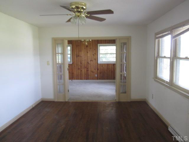 7949 Autry Mill Road Dunn, NC 28334 - Photo 2 of 7 an empty room with wooden floor chandelier fan and windows