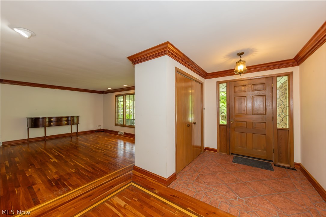 25001 Letchworth Road Beachwood, OH 44122 - Photo 3 of 50 Entryway featuring a wood-panel door with sidelight windows, a decorative ceiling-mounted light fixture, and tile flooring
