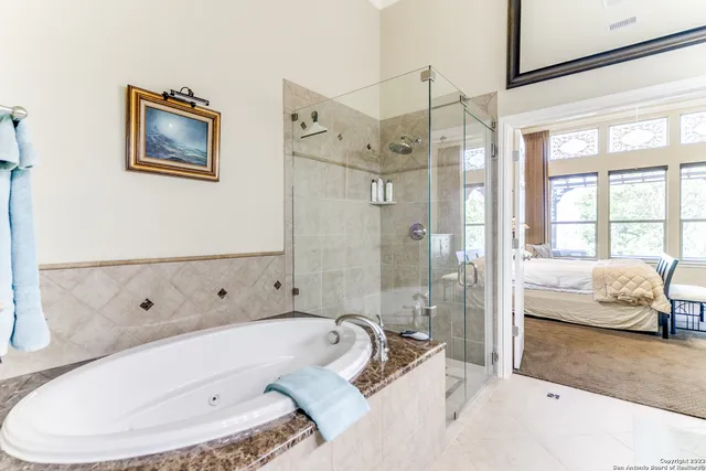 a bathroom with a tub shower and sink