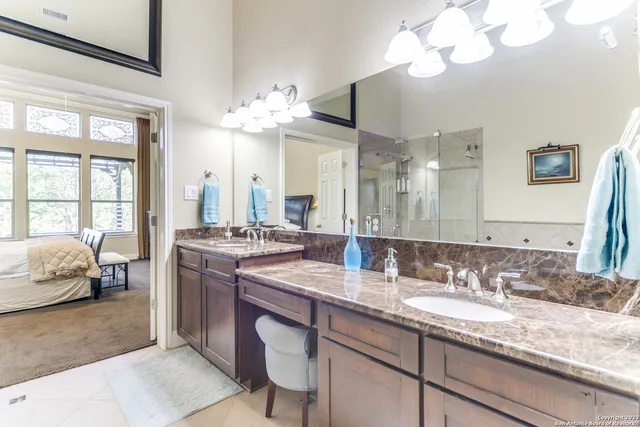 a en suite bathroom with a granite countertop sink mirror and a bathtub