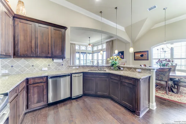a kitchen with granite countertop a sink cabinets and wooden floor