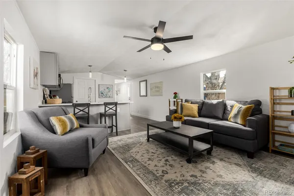 a living room with furniture and a view of kitchen
