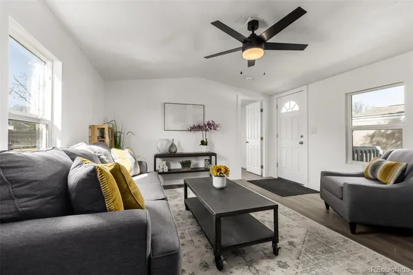 a living room with furniture a ceiling fan and a window