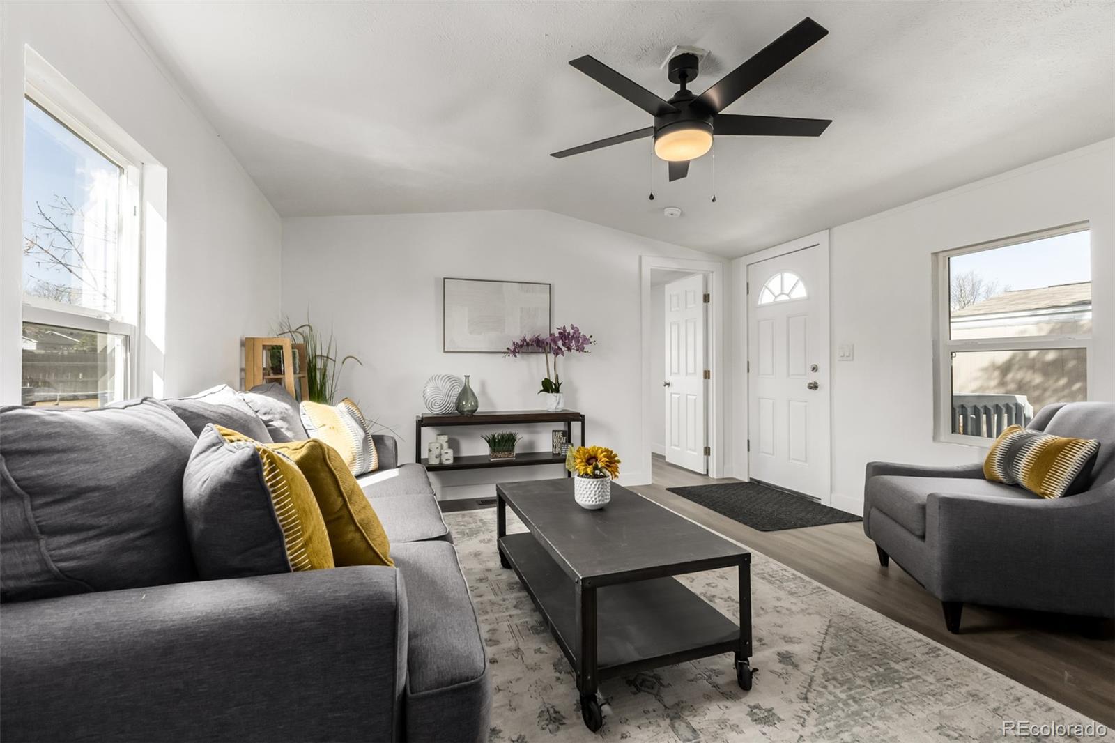 103 North Josephine Avenue Milliken, CO 80543 - Photo 4 of 14 a living room with furniture a ceiling fan and a window