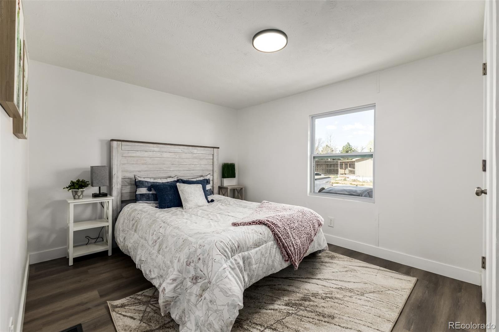 103 North Josephine Avenue Milliken, CO 80543 - Photo 8 of 14 a bedroom with a bed and a window