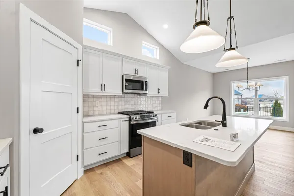 a kitchen with appliances a sink and cabinets
