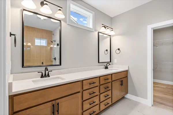 a bathroom with a double vanity sink and mirror