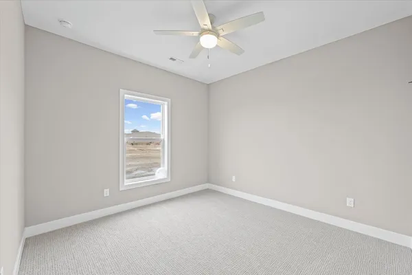 an empty room with a window and a ceiling fan