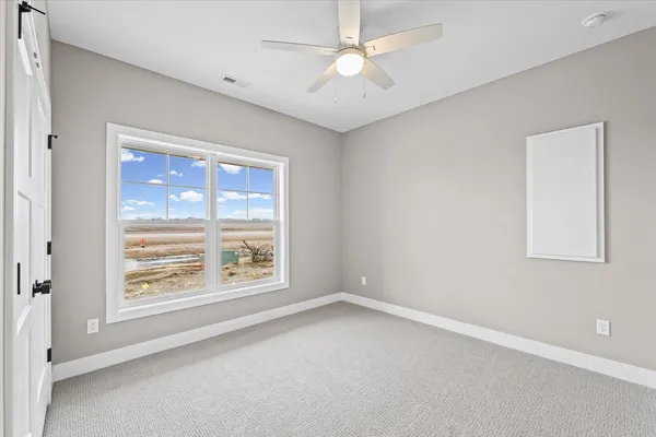 en empty room with windows and ceiling fan