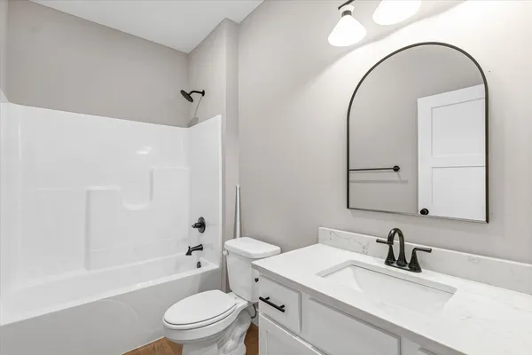 a bathroom with a granite countertop sink a toilet and a mirror