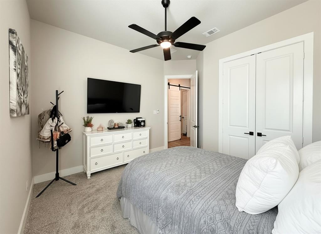 12116 Magma Court Krum, TX 76249 - Photo 17 of 30 a bed room with furniture and flat screen tv