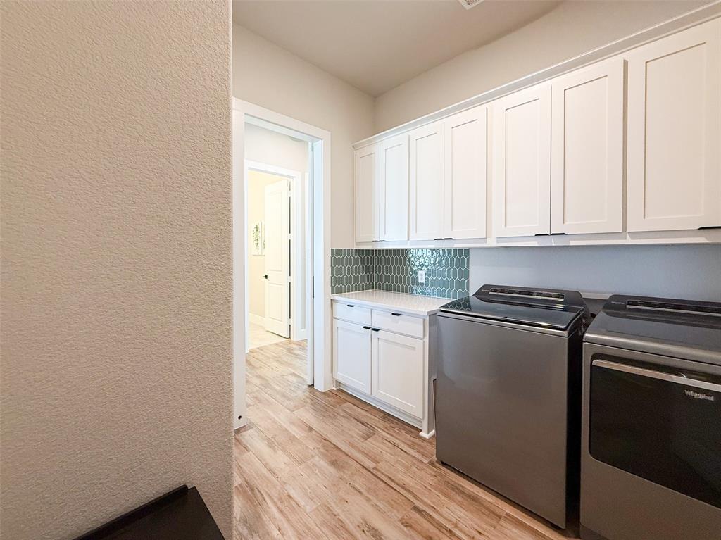 12116 Magma Court Krum, TX 76249 - Photo 24 of 30 a kitchen with granite countertop white cabinets and white appliances
