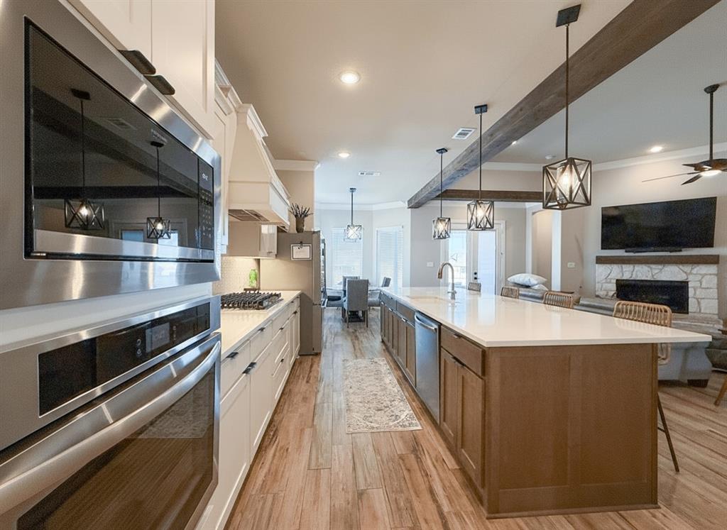 12116 Magma Court Krum, TX 76249 - Photo 7 of 30 a large kitchen with stainless steel appliances kitchen island a stove and a sink