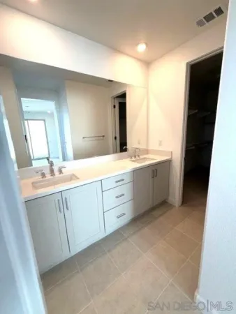 a spacious bathroom with a double vanity sink a toilet and a shower