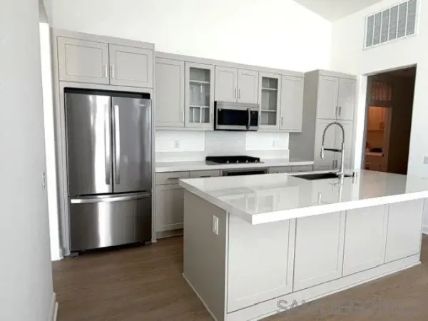 a kitchen with stainless steel appliances a refrigerator sink and microwave