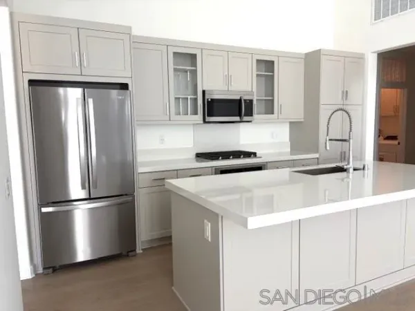 a kitchen with stainless steel appliances a refrigerator sink and microwave