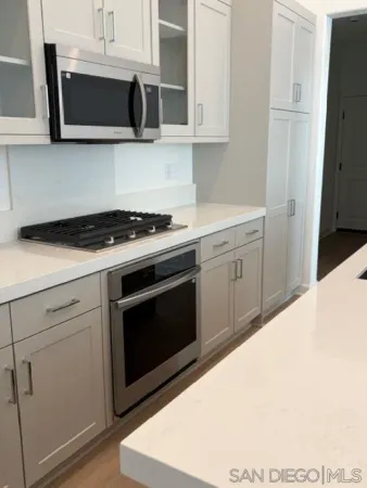 a kitchen with stainless steel appliances granite countertop a stove a microwave and cabinets