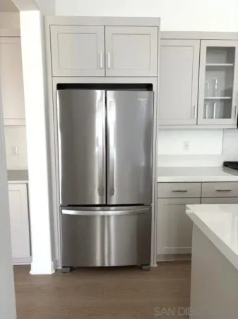 a living room with stainless steel appliances kitchen island granite countertop a sink and cabinets
