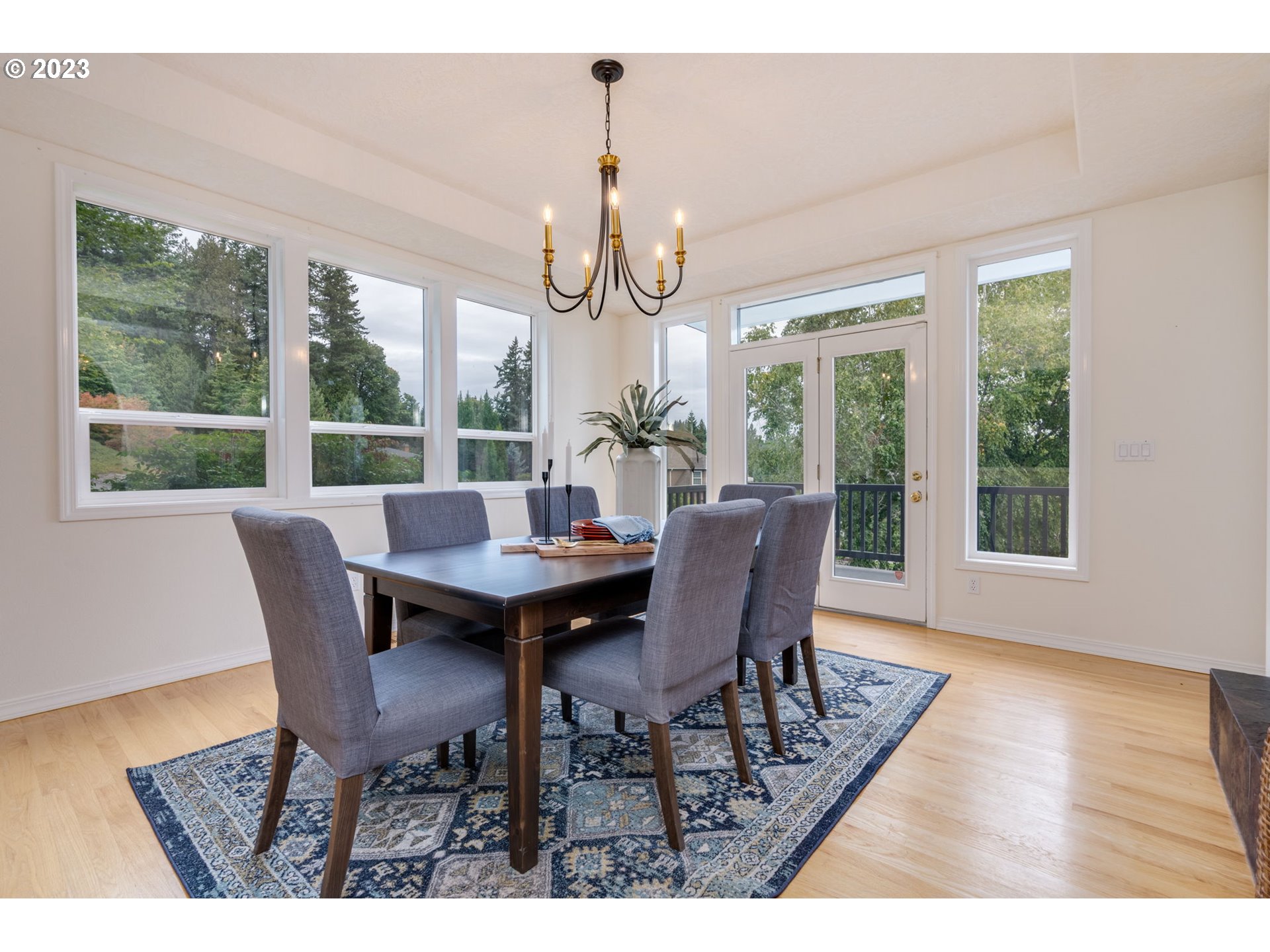 2842 Southeast Morlan Place Gresham, OR 97080 - Photo 15 of 46 a dining room with wooden floor a chandelier a wooden table and chairs
