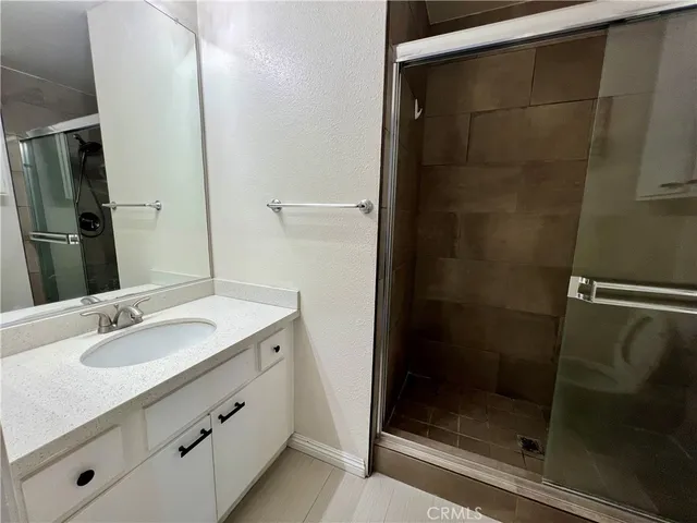 a bathroom with a shower sink and mirror