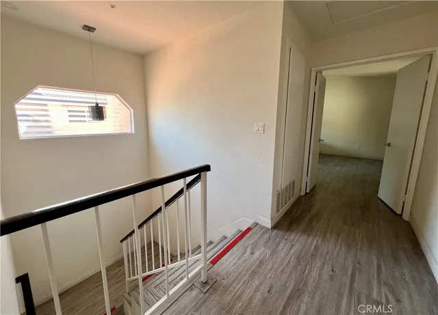 a view of a hallway with wooden floor and staircase