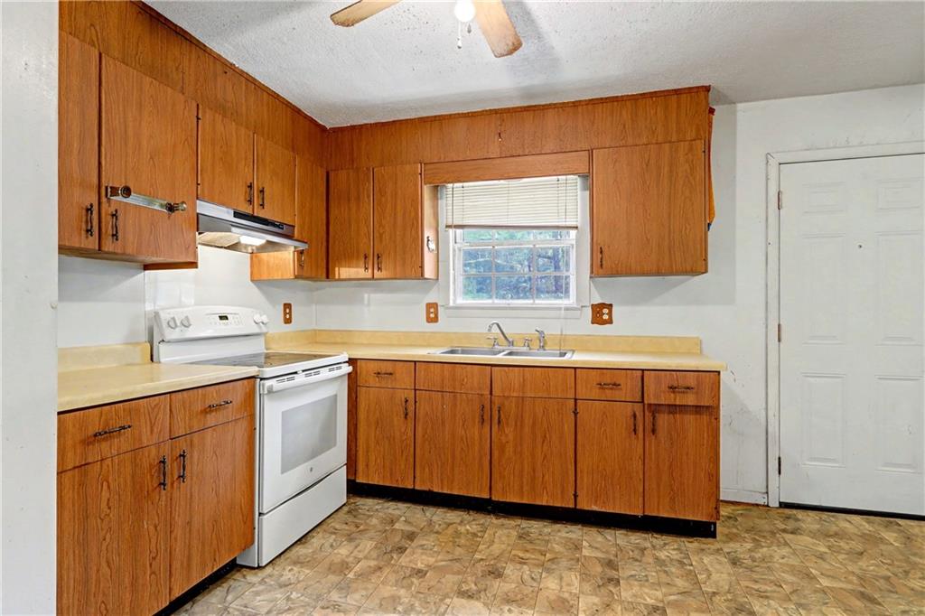1408 Prospect Road Chickamauga, GA 30707 - Photo 6 of 27 a kitchen with stainless steel appliances granite countertop a sink stove and cabinets
