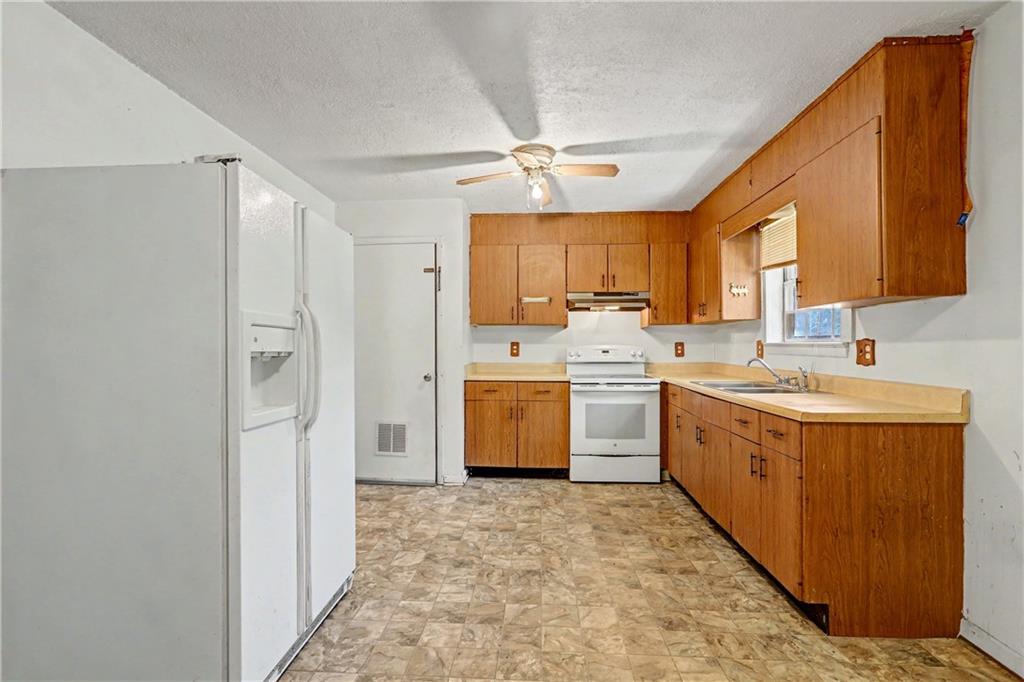 1408 Prospect Road Chickamauga, GA 30707 - Photo 7 of 27 a kitchen with a sink refrigerator and cabinets
