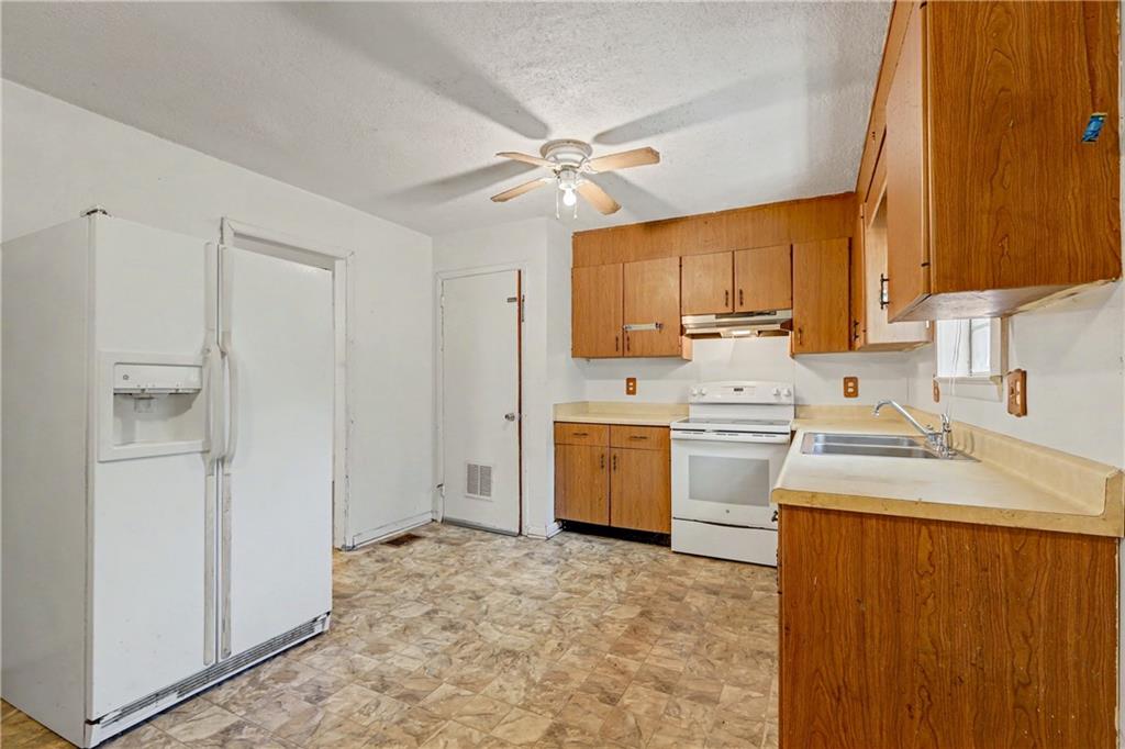 1408 Prospect Road Chickamauga, GA 30707 - Photo 8 of 27 a kitchen with a sink a stove cabinets and a window