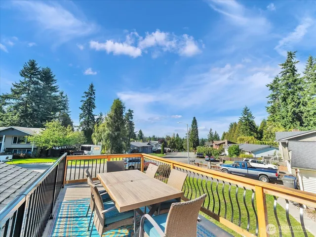 a view of a balcony with wooden floor and outdoor seating