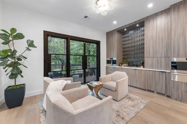 a living room with furniture kitchen and a large window