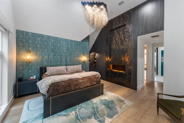 a spacious bedroom with a bed and a chandelier